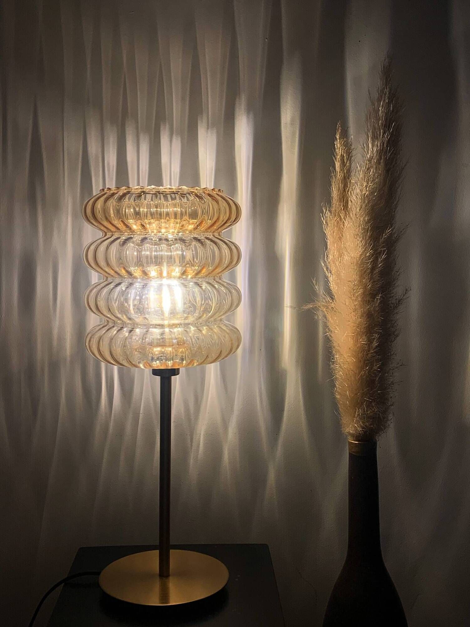 Table lamp with an old vintage golden striped globe and a golden foot