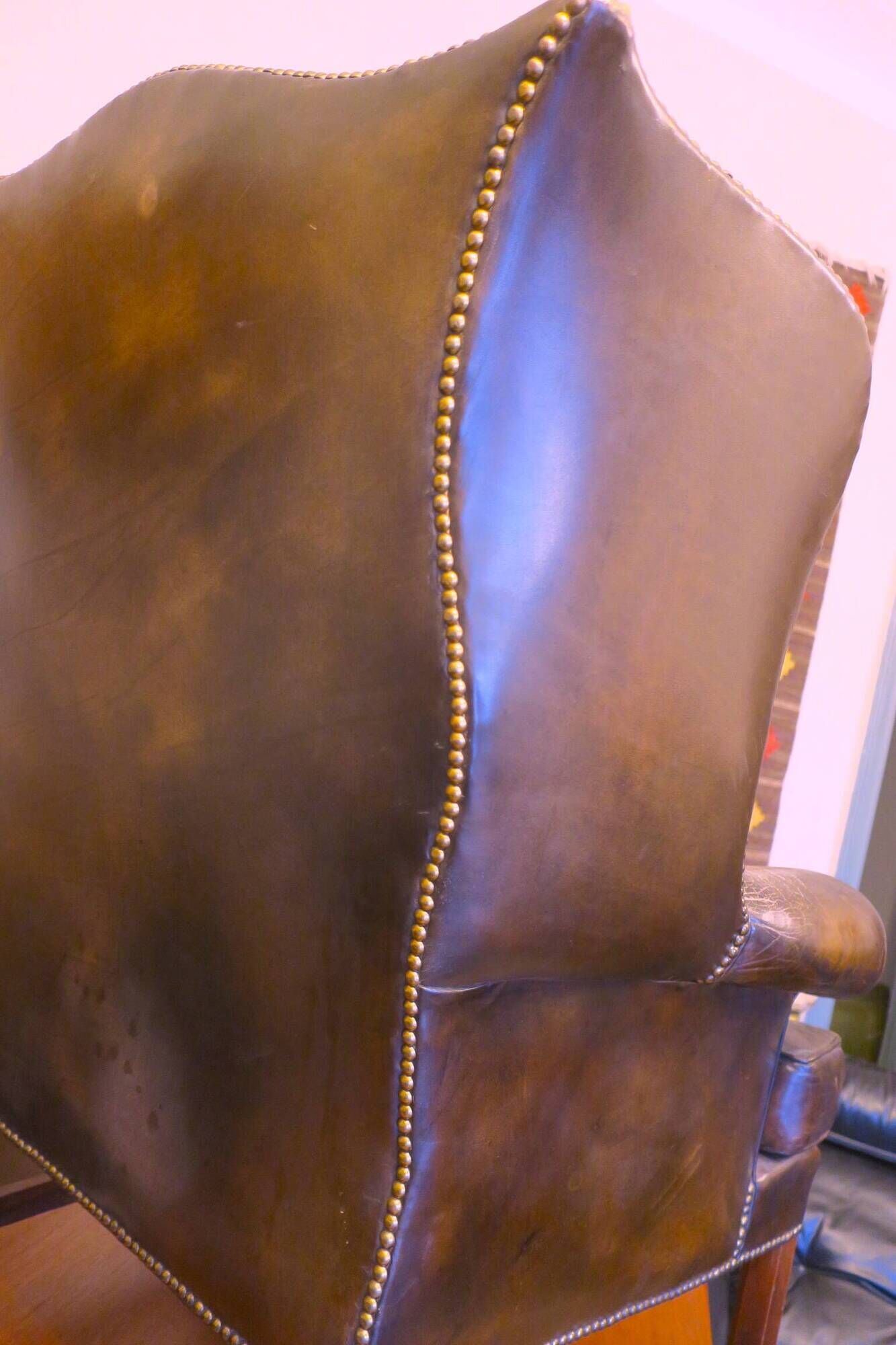 Wingback armchair in dark brown patinated leather, 1970s