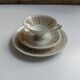 Solitaire tea cup, saucer, and dessert plate in white and gold.