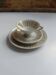 Solitaire tea cup, saucer, and dessert plate in white and gold.