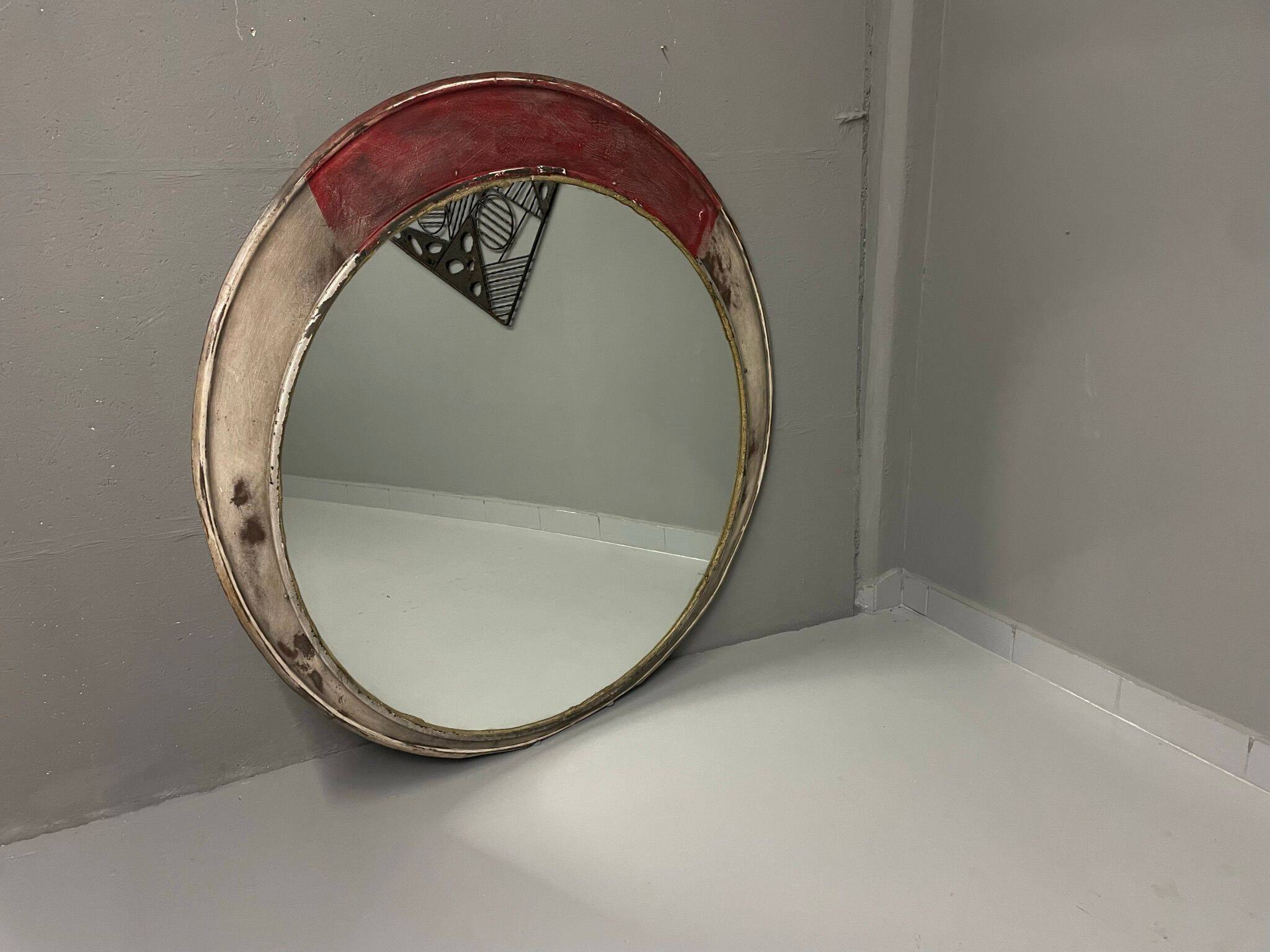 Vintage round mirror with an industrial metal frame in a painted finish.