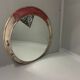 Vintage round mirror with an industrial metal frame in a painted finish.