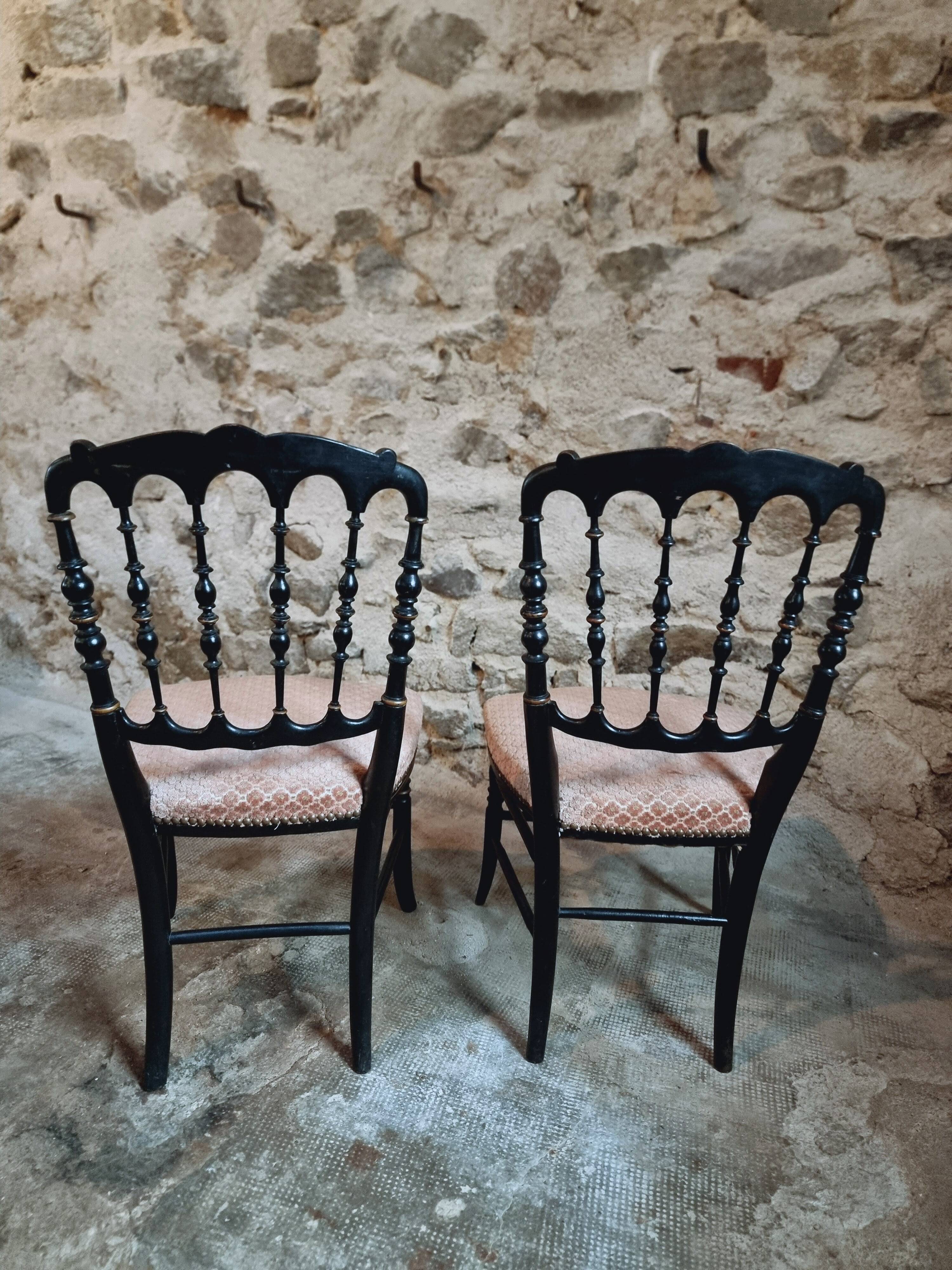 Pair of antique Napoleon III chairs in blackened wood and fabric.