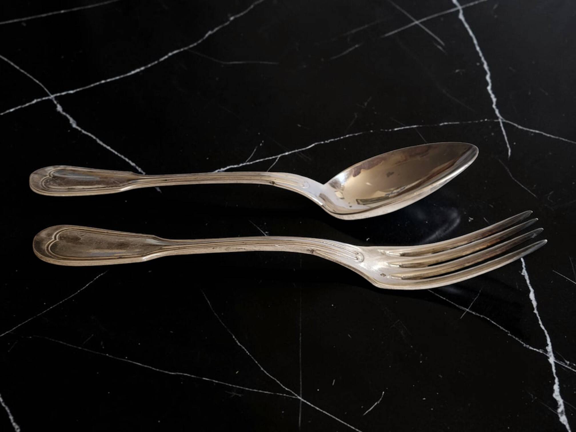 24 silver-plated metal table settings in the filet model.