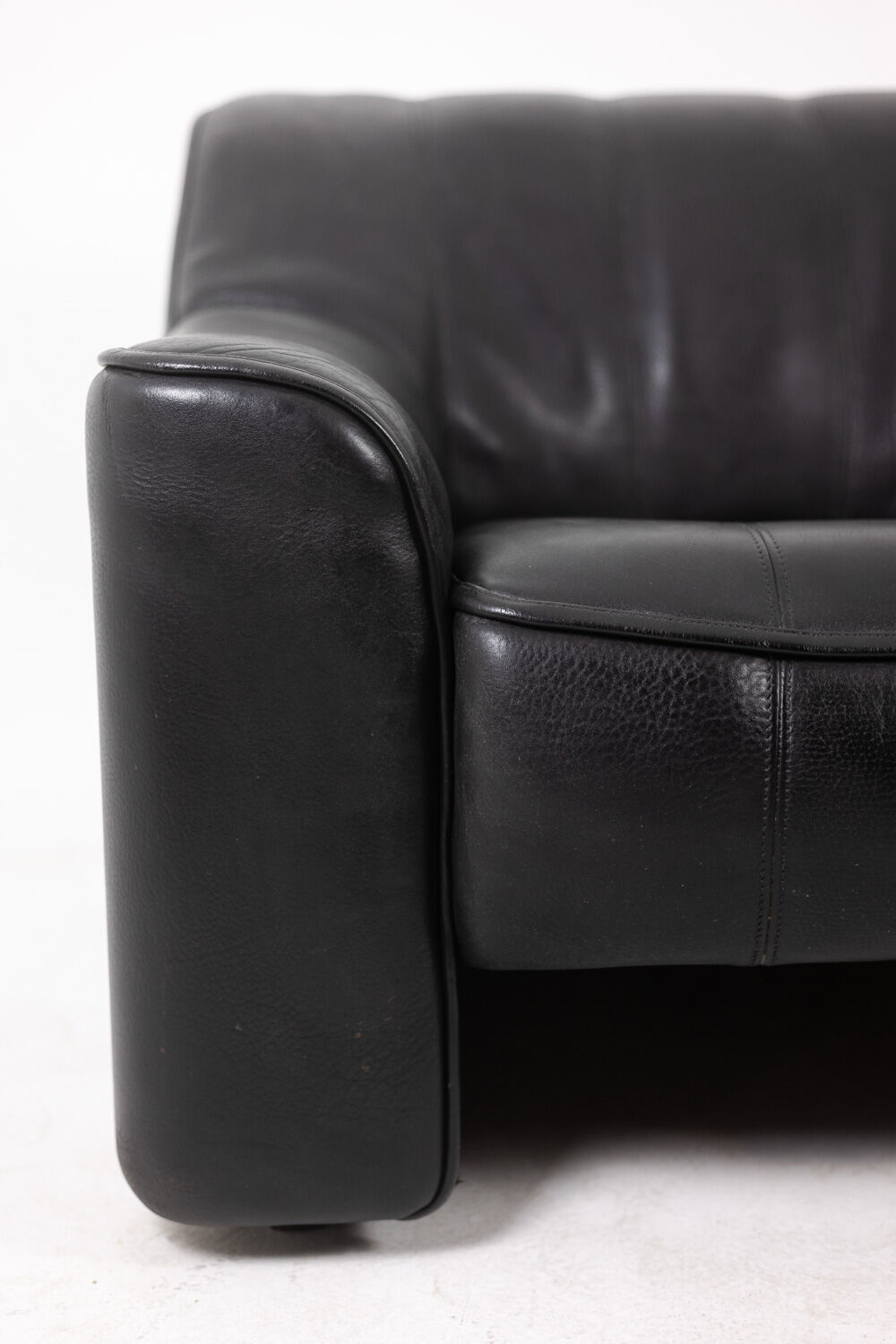 Maison De Sede. Armchair and its ottoman in black leather. 1970s.
