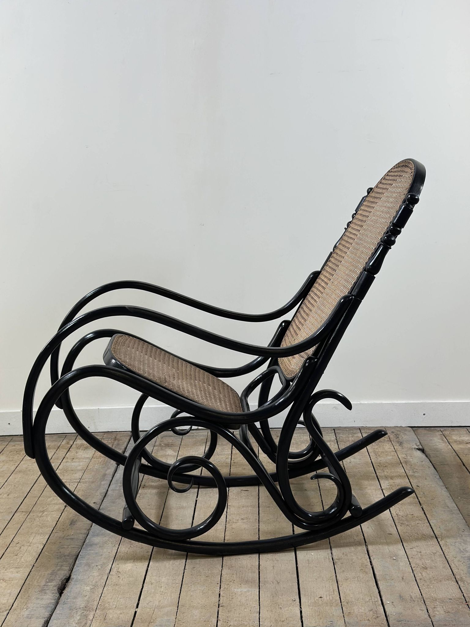Rocking chair in blackened curved wood and cane, 1900s