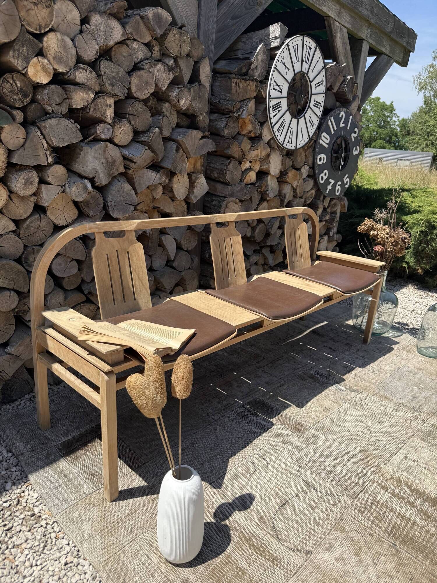 Baumann bench with wooden frame and faux leather seat.
