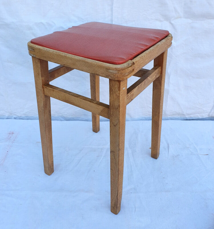 Vintage wooden stool and red skai seat