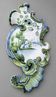 Wall-mounted bouquet holder in polychrome earthenware, with a wavy shape.