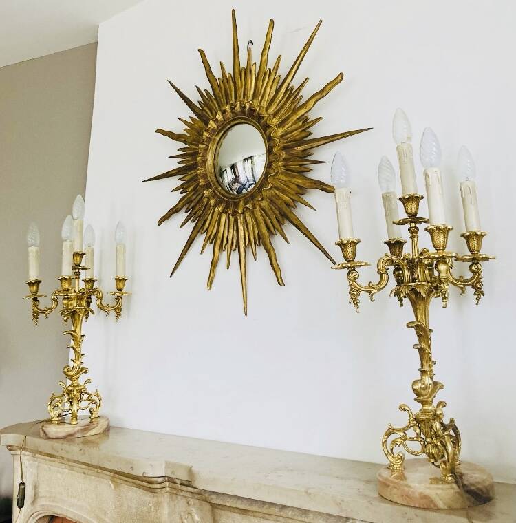 Massive gilded bronze chandeliers from the mid-20th century with marble bases.