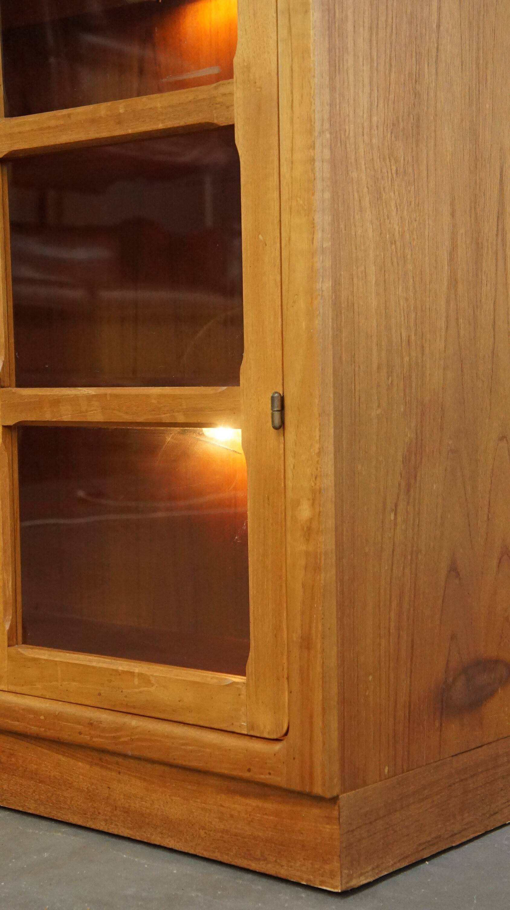 Elegant vintage Danish display cabinet with glass panels and atmospheric lighting
