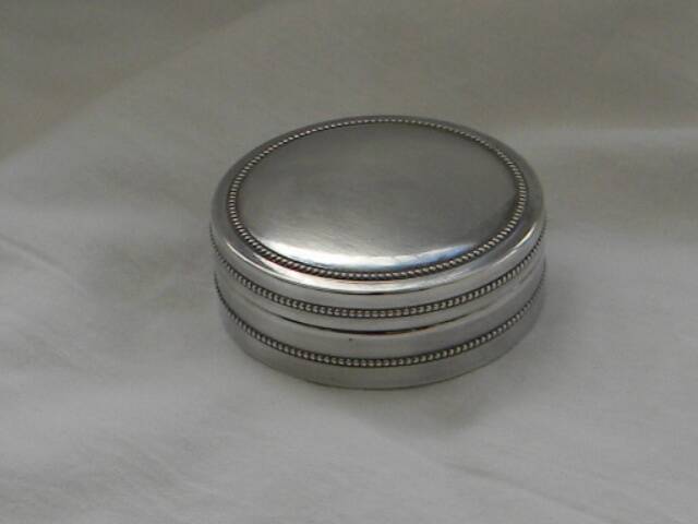 Small round silver metal box SNPA.