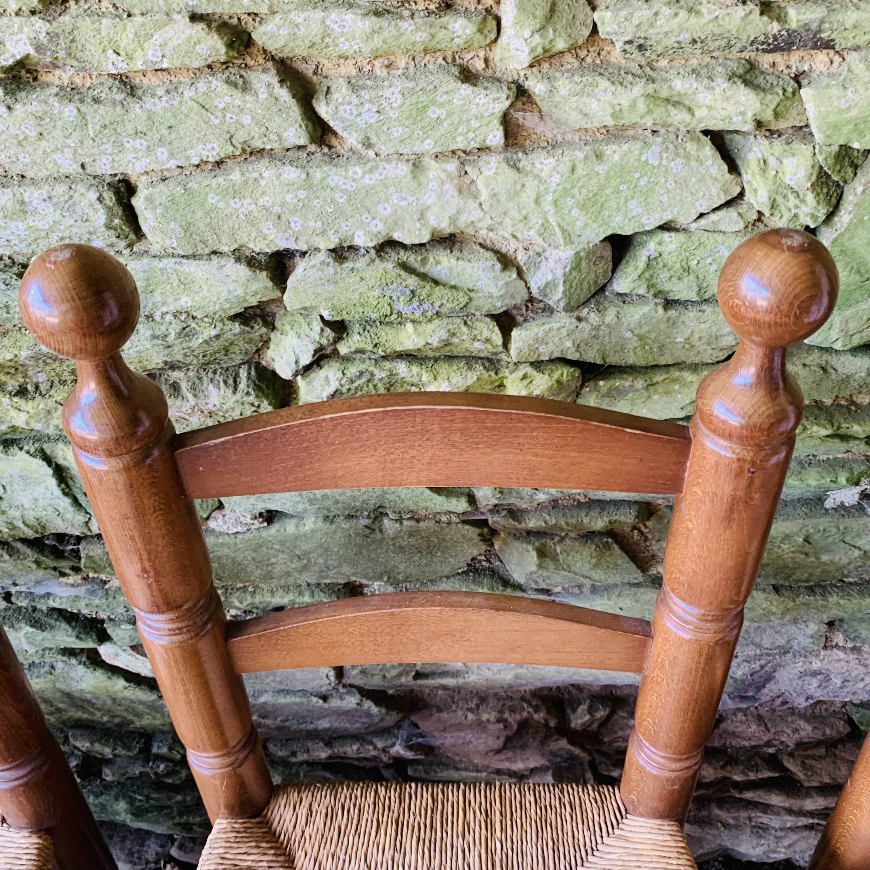 Set of 4 solid wood chairs with straw seats.