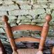 Set of 4 solid wood chairs with straw seats.