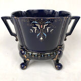 Large earthenware pot cover with enamelled decoration on a blue oven background