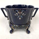 Large earthenware pot cover with enamelled decoration on a blue oven background