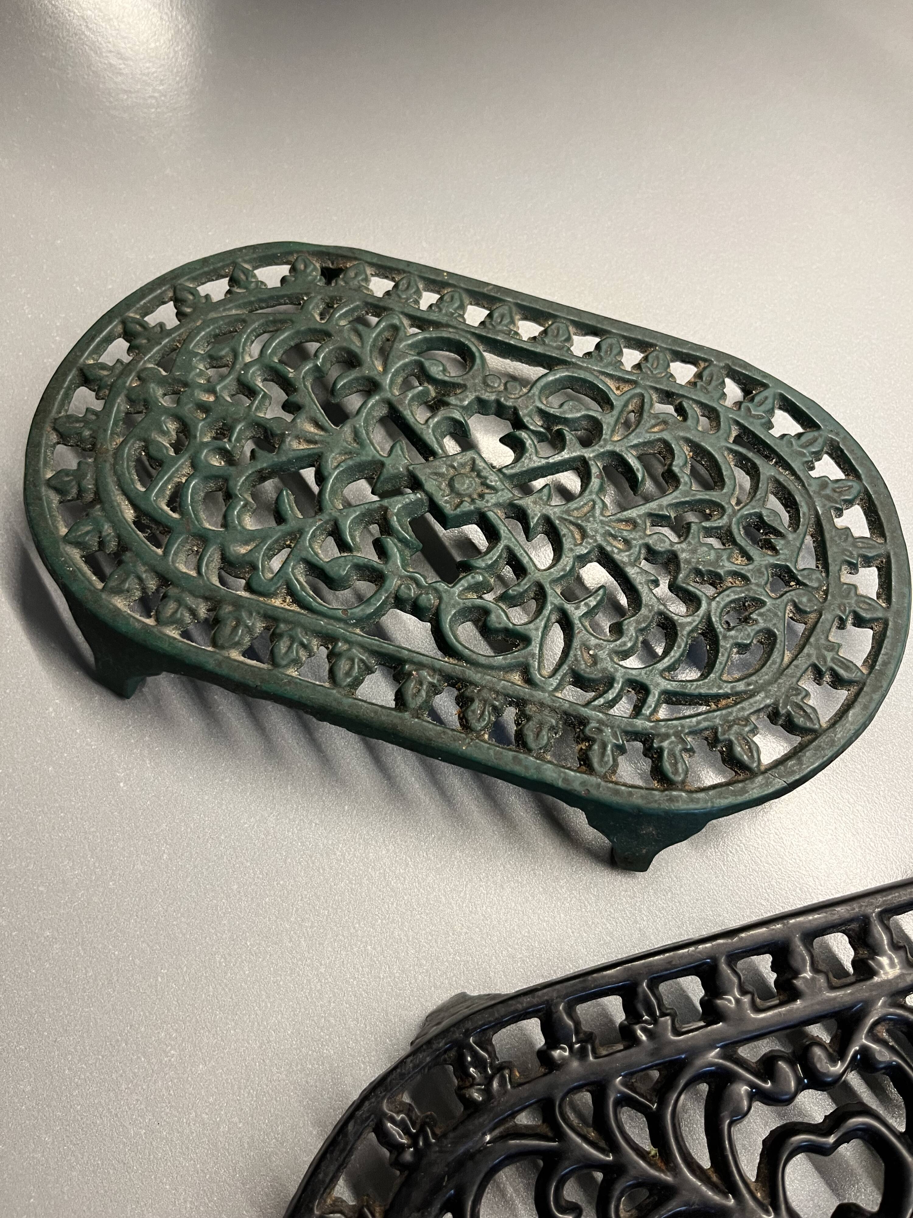 Duo of antique cast iron table mats