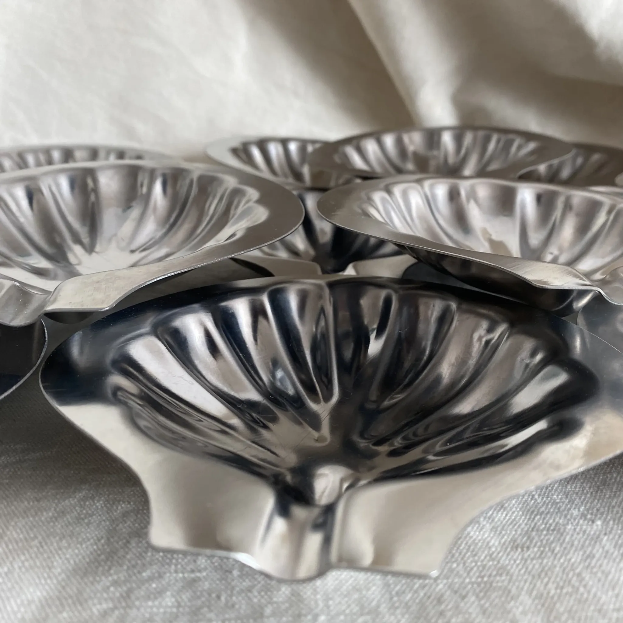 Set of 12 stainless steel scallop shells, 1970s-80s.