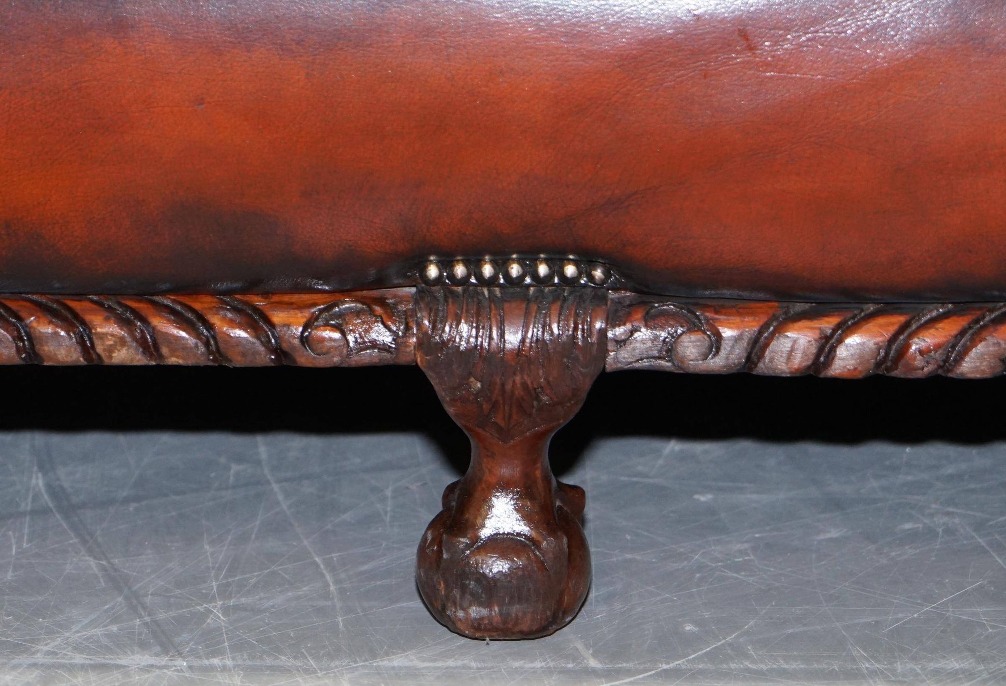 Restored Victorian sofa in leather with claw feet and feather cushions.