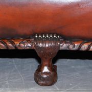 Restored Victorian sofa in leather with claw feet and feather cushions.