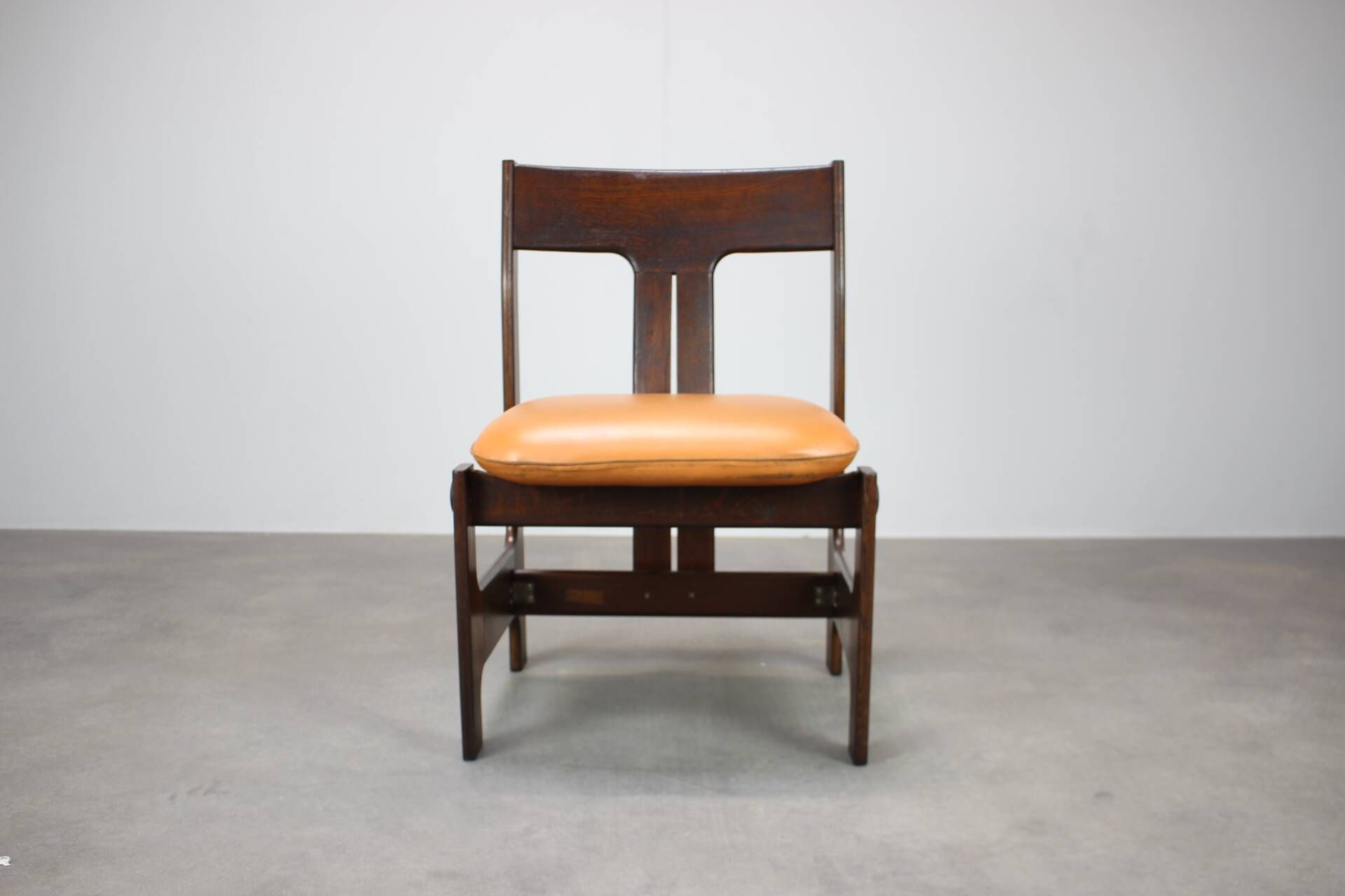 Vintage German sculptural chair from the 1970s in wood with orange faux leather.