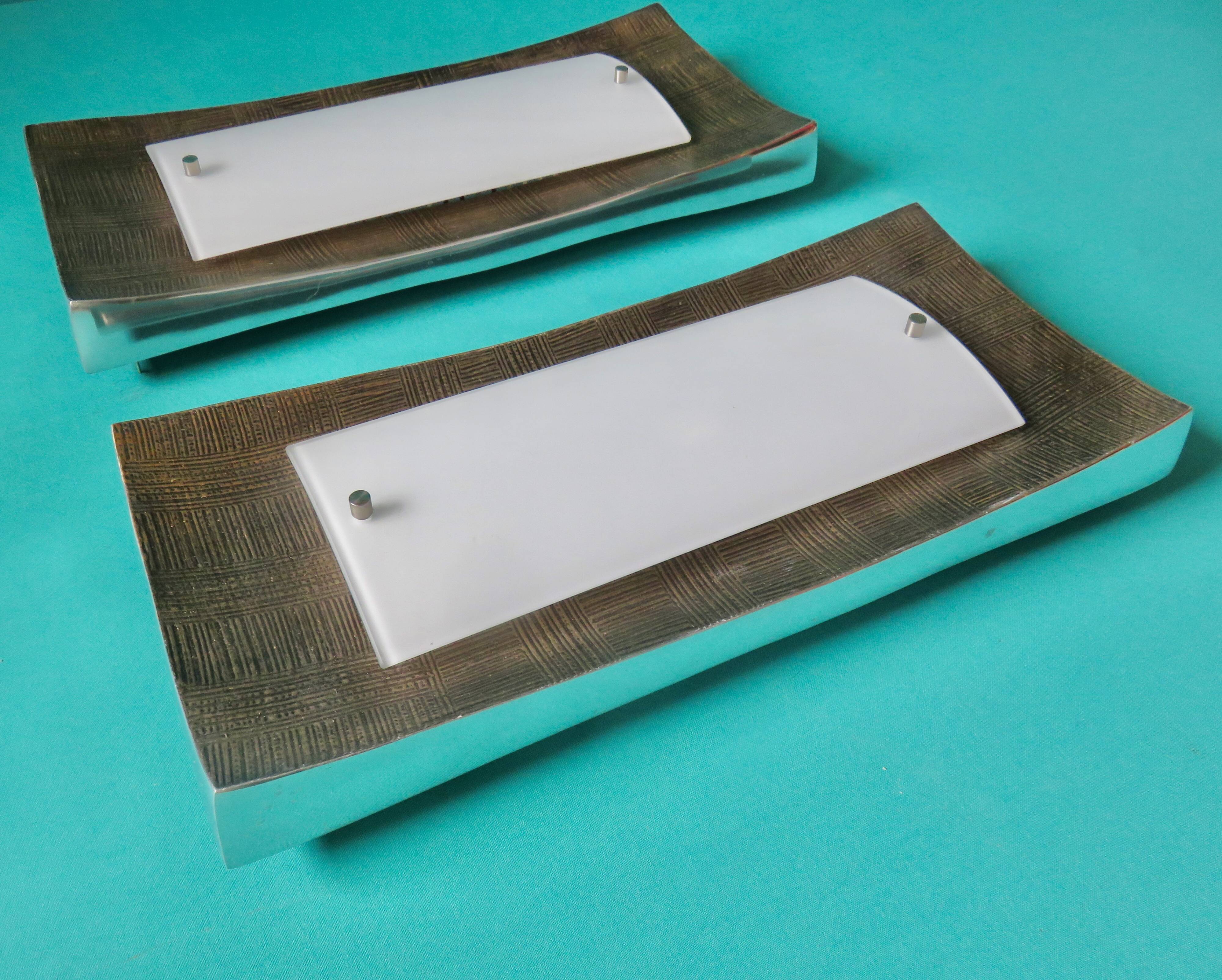 Pair of wall sconces in gold-plated alloy with bas-relief and opaline glass. Germany, 1980