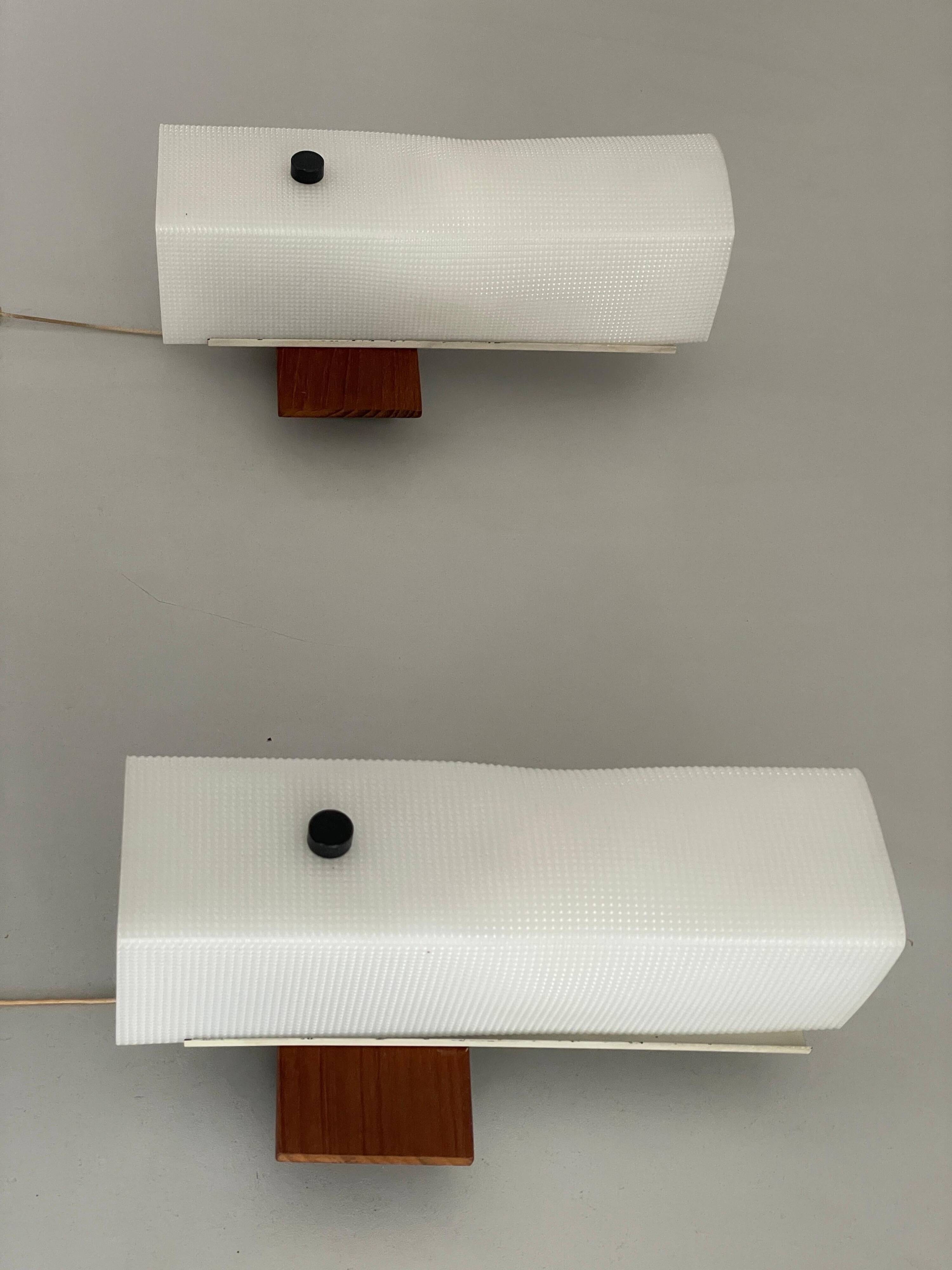 Mid-century wall lights in white plexiglass with a wooden base, 1960s, Germany.