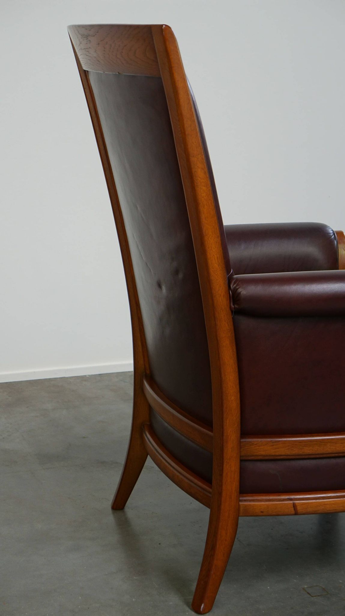 Very comfortable classic cowhide armchair with a high back in a mild Art Deco style