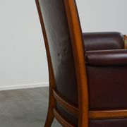 Very comfortable classic cowhide armchair with a high back in a mild Art Deco style