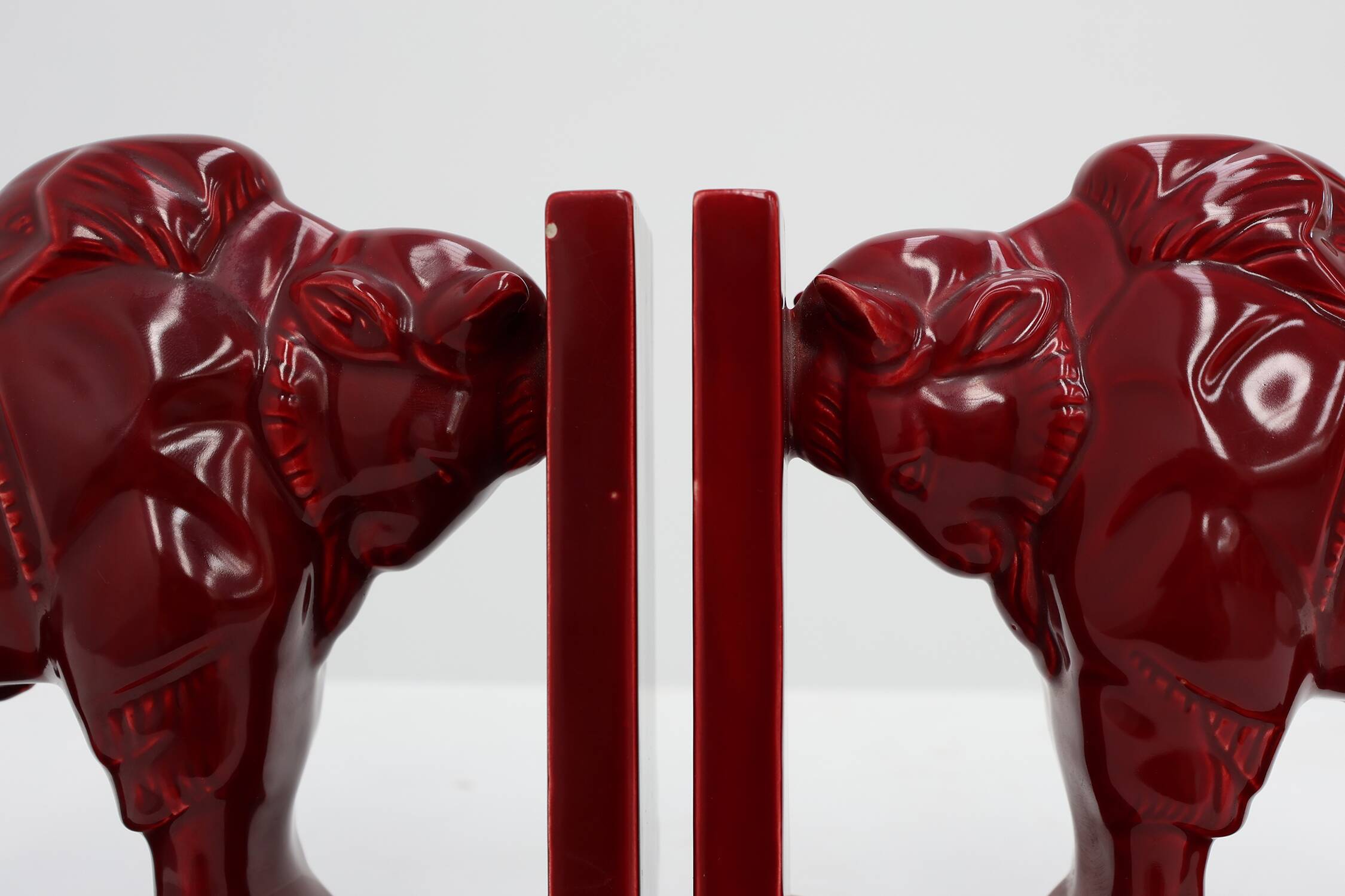 Pair of red glazed ceramic Bison ox bookends in Art Deco style, Belgium