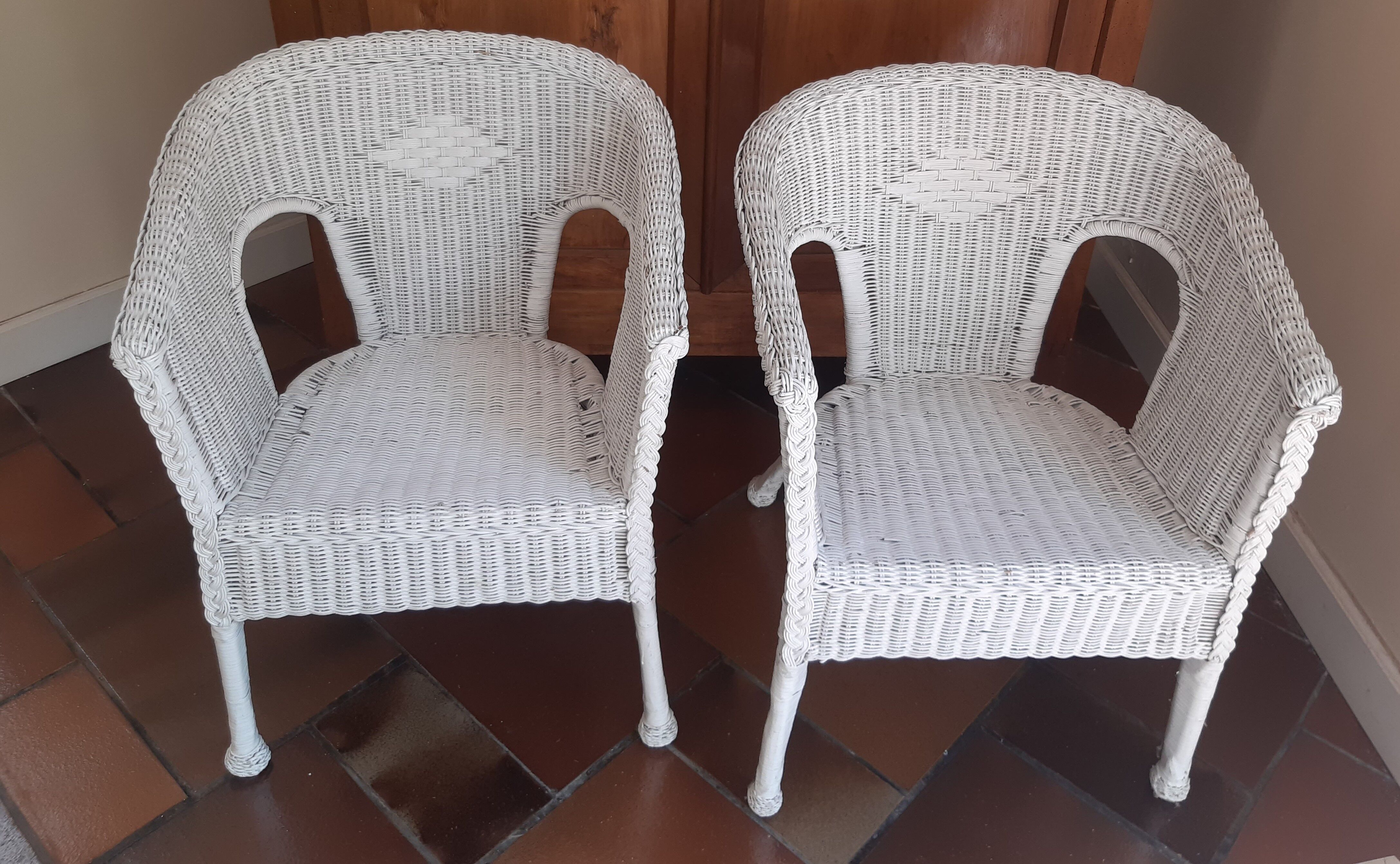 2 white wicker armchairs