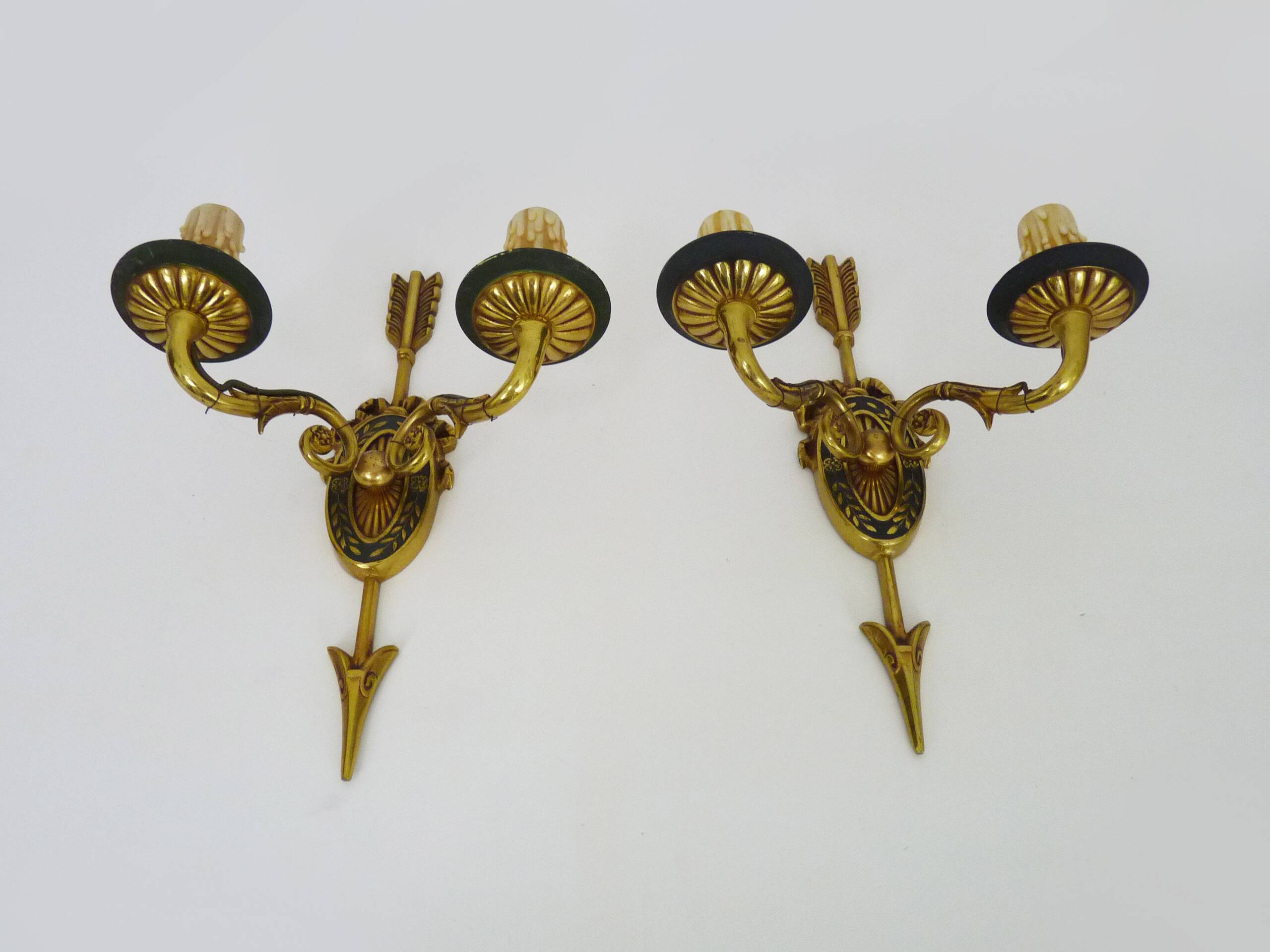 Pair of double-light Empire style arrow wall lights in bronze. Early 20th century