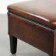 Large dark brown square ottoman made of sheepskin with black piping