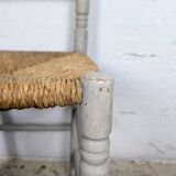 Rustic chair made of turned wood and straw.