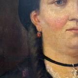 Old oil painting on canvas portrait of a woman with a red bow, late 19th century