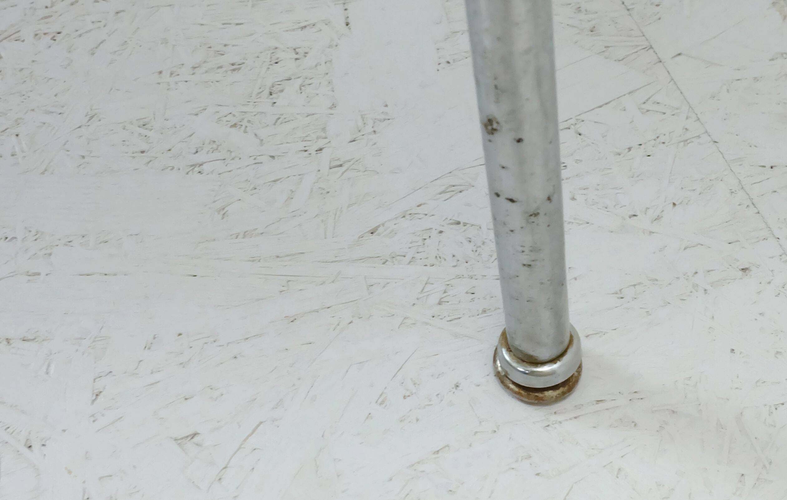 Table basse des années 1950 à trois pieds avec un plateau en formica et des pieds en chrome inclinés.