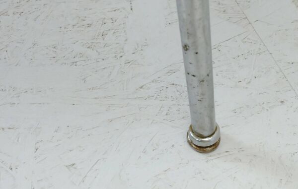 Table basse des années 1950 à trois pieds avec un plateau en formica et des pieds en chrome inclinés.