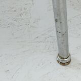 Table basse des années 1950 à trois pieds avec un plateau en formica et des pieds en chrome inclinés.