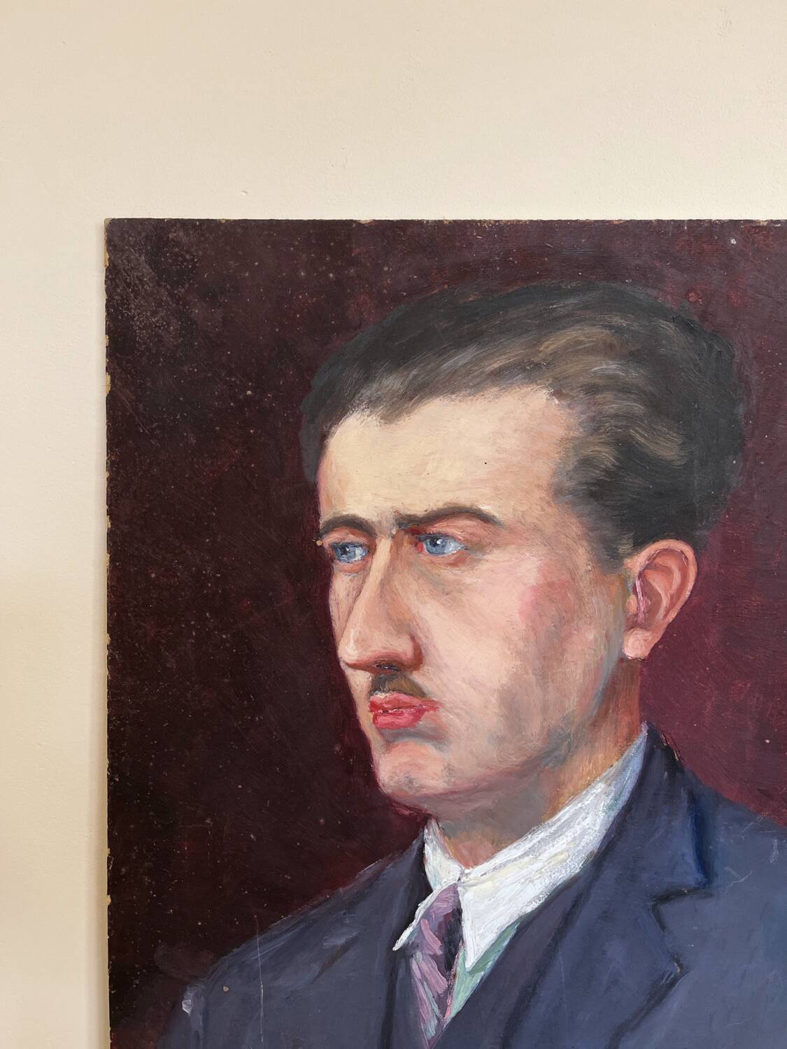 Old oil painting on cardboard portrait of a man in a blue suit