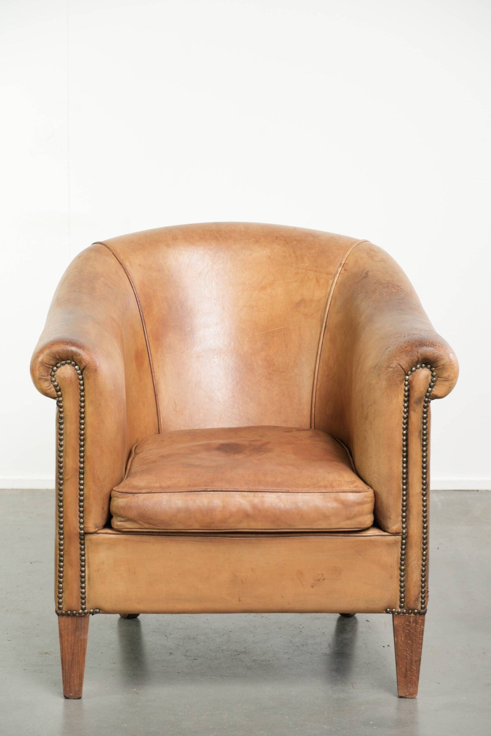 Fauteuil club en peau de mouton confortable de couleur cognac.