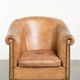 Fauteuil club en peau de mouton confortable de couleur cognac.