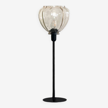 Table lamp with a striated star-shaped globe and a black base