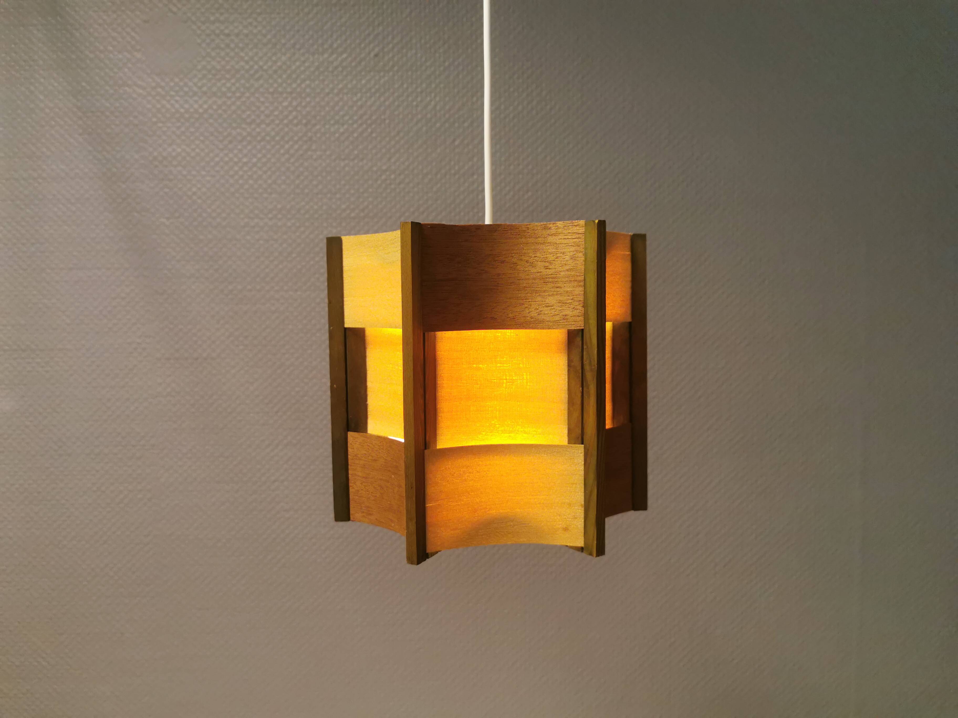 Older lamp in wood veneer, partially painted in green colour.