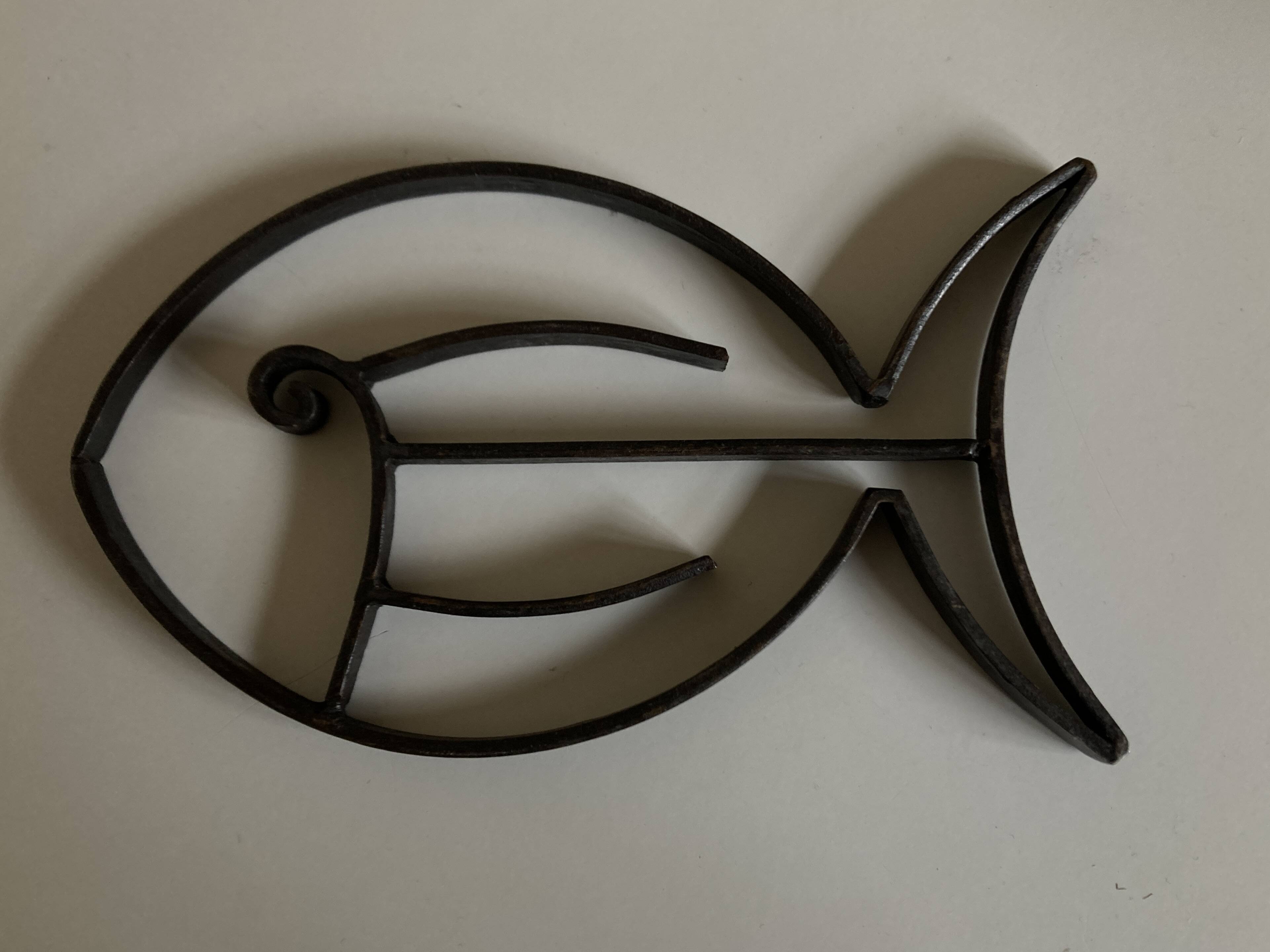 Modernist fish trivet in beaten iron, 1960.