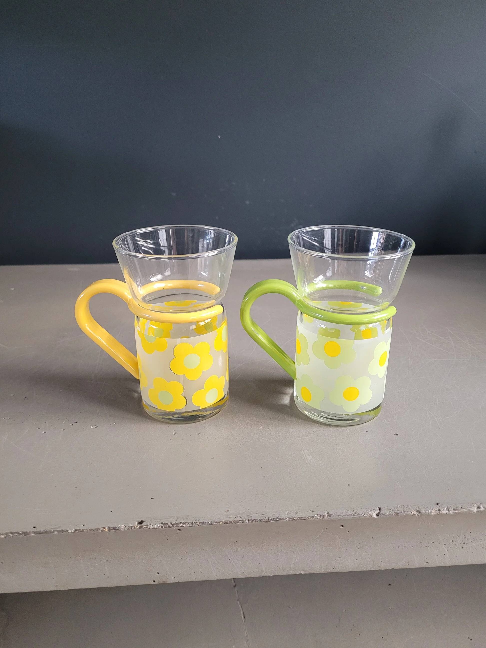 Pair of glass teacups with plastic handles