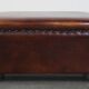 Cognac-colored sheepskin stool with decorative studs