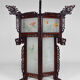 Asian wooden lantern carved with dragons and painted glass panels