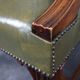 Elegant armchair and footrest in English green leather