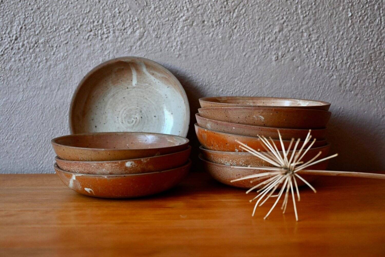 Set of 10 turned stoneware plates, pyritised and glazed, wabi-sabi brutalist.