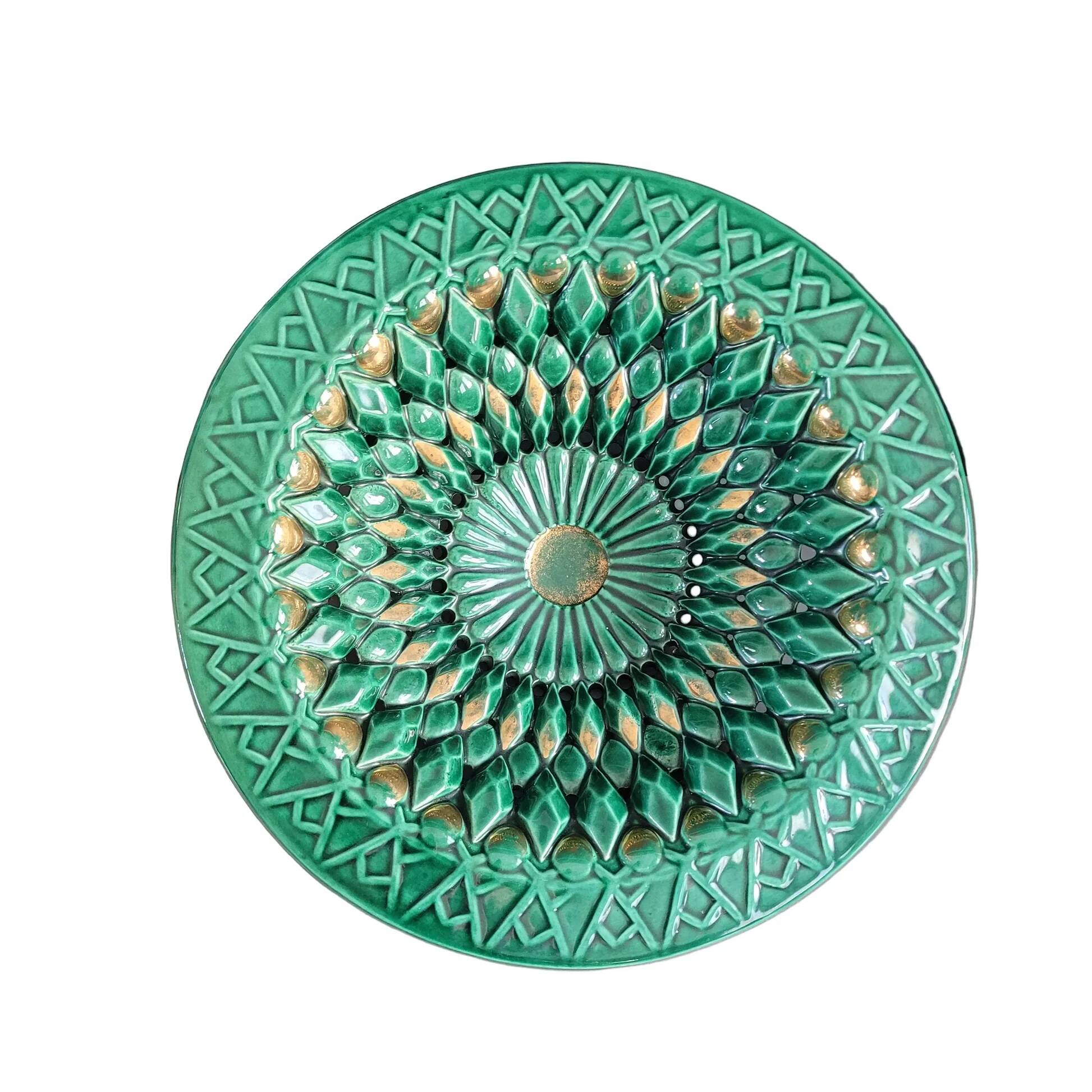 Large pierced earthenware fruit bowl glazed in green and gold.